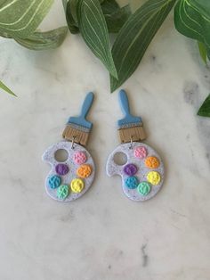 pair of earrings with paintbrush and crochet details