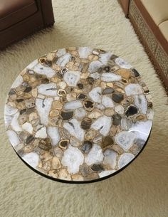 a glass table with rocks on it in the middle of a carpeted living room