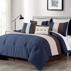 a bed with blue and brown comforters in a bedroom