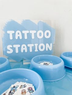 a blue table topped with plates and bowls covered in tattoos on it's sides