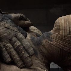 the hands of an old woman are covered in mud and cloths, as if they were holding something