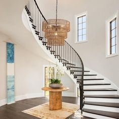 a large foyer with a chandelier and wooden table in front of the stairs