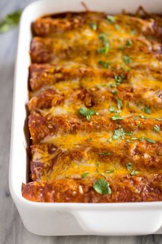 a casserole dish with meat and cheese on top, garnished with parsley