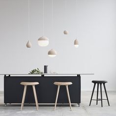 an island with stools and lights hanging from it