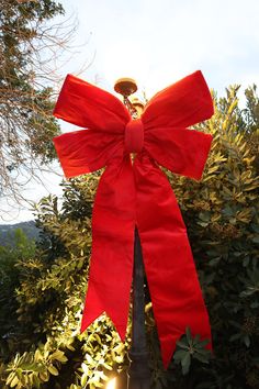 a large red bow on top of a light post