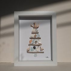 a white frame with a christmas tree made out of seashells