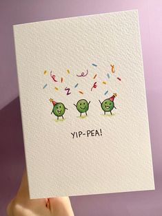 a hand holding up a card that says yip - pea with two green birds on it