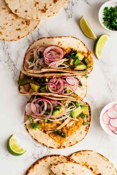 three tortillas with onions, avocado and cilantro on top