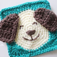 a crocheted square with a dog's face on it