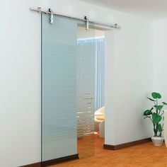 an empty room with a plant and sliding glass doors on the door to another room