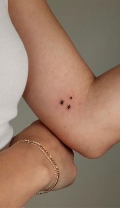 a woman's arm with three stars on the left side of her body,