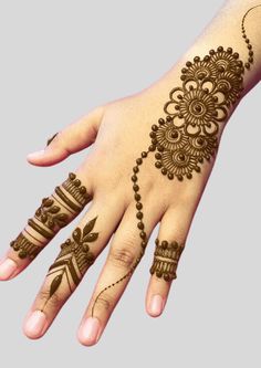 a hand with henna tattoos on it and an armband in the shape of a flower