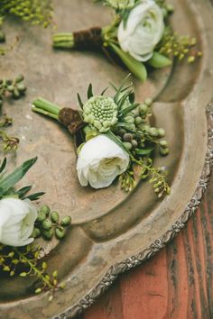 some white flowers and green leaves on a tray