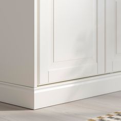 a close up of a white cabinet door on the floor with a checkered rug