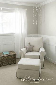 a baby's room with a white chair and chandelier hanging from the ceiling