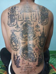 the back of a man with tattoos on his body and chest is covered in intricate designs