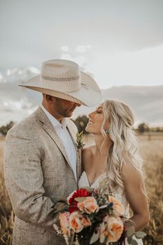 a man and woman standing next to each other in a field