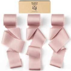 four pieces of pink satin ribbon on a white background