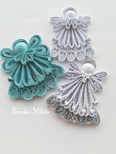 three different types of brooches on a white surface, one is blue and the other has silver filigreets