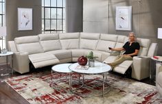 a woman sitting on top of a white couch in a living room