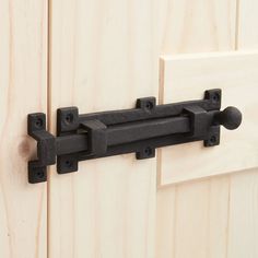 a close up of a door handle on the side of a wooden door with black hardware