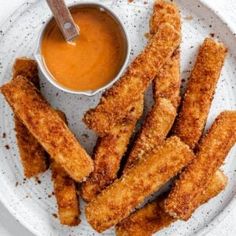 fried fish sticks on a plate with dipping sauce