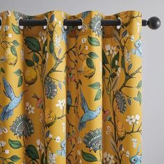 a yellow curtain with birds and flowers on it