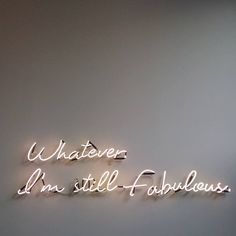 a neon sign that says whatever i'm still fabulous on the side of a wall