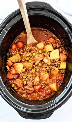 a crock pot filled with meat and vegetables