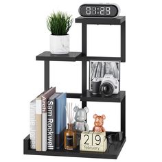 a black shelf with books and an alarm clock