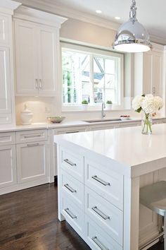 a large kitchen with white cabinets and an island