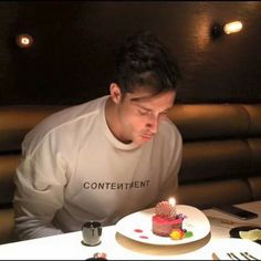 a man blowing out the candles on his cake