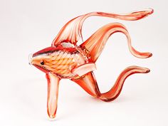 a glass figurine of a fish on a white background