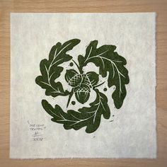 a piece of paper with an image of leaves and acorns in the center