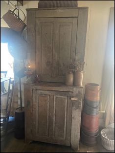 an old wooden cabinet sitting on top of a hard wood floor next to a window