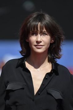 a woman with short hair wearing a black shirt