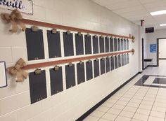 an empty hallway with several bulletin boards on the wall and bows hanging from the doors