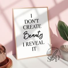 a poster with the words i don't create beauty reveal it next to a potted plant