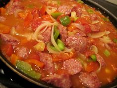 a pan filled with meat and vegetables on top of a stove