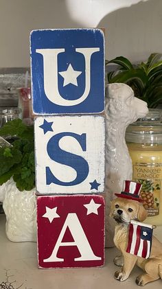 a wooden block with the word usa painted on it and a dog figurine next to it