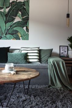 a living room with a couch, coffee table and painting on the wall behind it