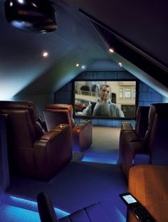 a home theater with leather recliners and blue lighting