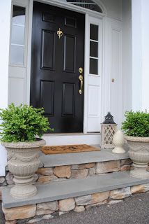 two planters on the front steps of a house