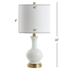 a white table lamp with a gold base and a white shade on the bottom side