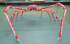 a large spider made out of plastic wrapped in red and white strips on the floor