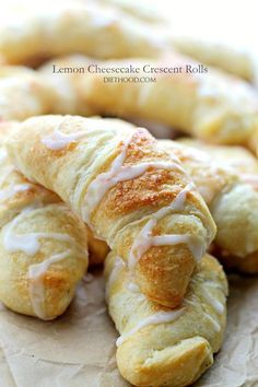 croissants with white icing on them sitting on top of wax paper