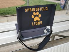 a black and yellow sign that says springfield lions on it's back with a paw print