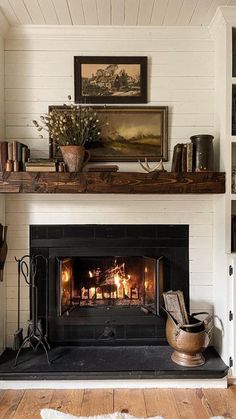 a fireplace in a living room with bookshelves and pictures on the wall above it