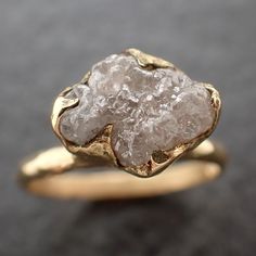 a close up of a gold ring with a rough stone in it's center