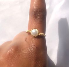 This simple gold, dainty, faux pearl ring is handmade out of wire, this ring is sturdy but can be bent, so a lot of force should not be applied to this! You only get 1 ring per purchase. I also sell matching pearl earrings, a simple pearl necklace and bridal pearl necklaces, these are all perfect to wear throughout the summer.  SIZING: - US 4 --- UK H--- Pandora size 46 --- 14.60mm (diameter) - US 4 1/2 --- UK H1/2 - I1/2 --- Pandora size 48 --- 15.30mm  - US 5 --- UK J-K --- Pandora size 50 --- 16.00 mm - US 5 1/2 --- UK K-L --- Pandora size 51 - 16.2 mm - US 6 --- UK L - L1/2 --- Pandora size 52 ---16.50mm - US 6 1/2 --- UK M --- Pandora size 53 --- 16.9mm - US 7 --- UK N --- Pandora size 54 --- 17.20mm - US 7 1/2 --- UK O - P --- Pandora size 56 --- 17.80mm - US 8 --- UK P --- Pandora s Adjustable Dainty Midi Rings, Dainty Stackable Metal Jewelry, Dainty Hypoallergenic Toe Ring Jewelry, Dainty Metal Stackable Jewelry, Dainty Metal Promise Ring, Adjustable Dainty Stackable Rings, Adjustable Minimalist Pearl Promise Ring, Minimalist Stackable Adjustable Pearl Ring, Adjustable Stackable Minimalist Pearl Ring